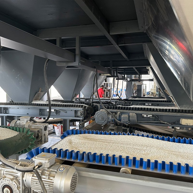 Industrial fertilizer processing area with batching hoppers and control panel
